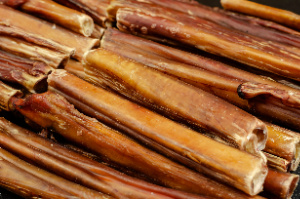 Close-up of dried chew pet treats, specifically bully sticks for dogs.